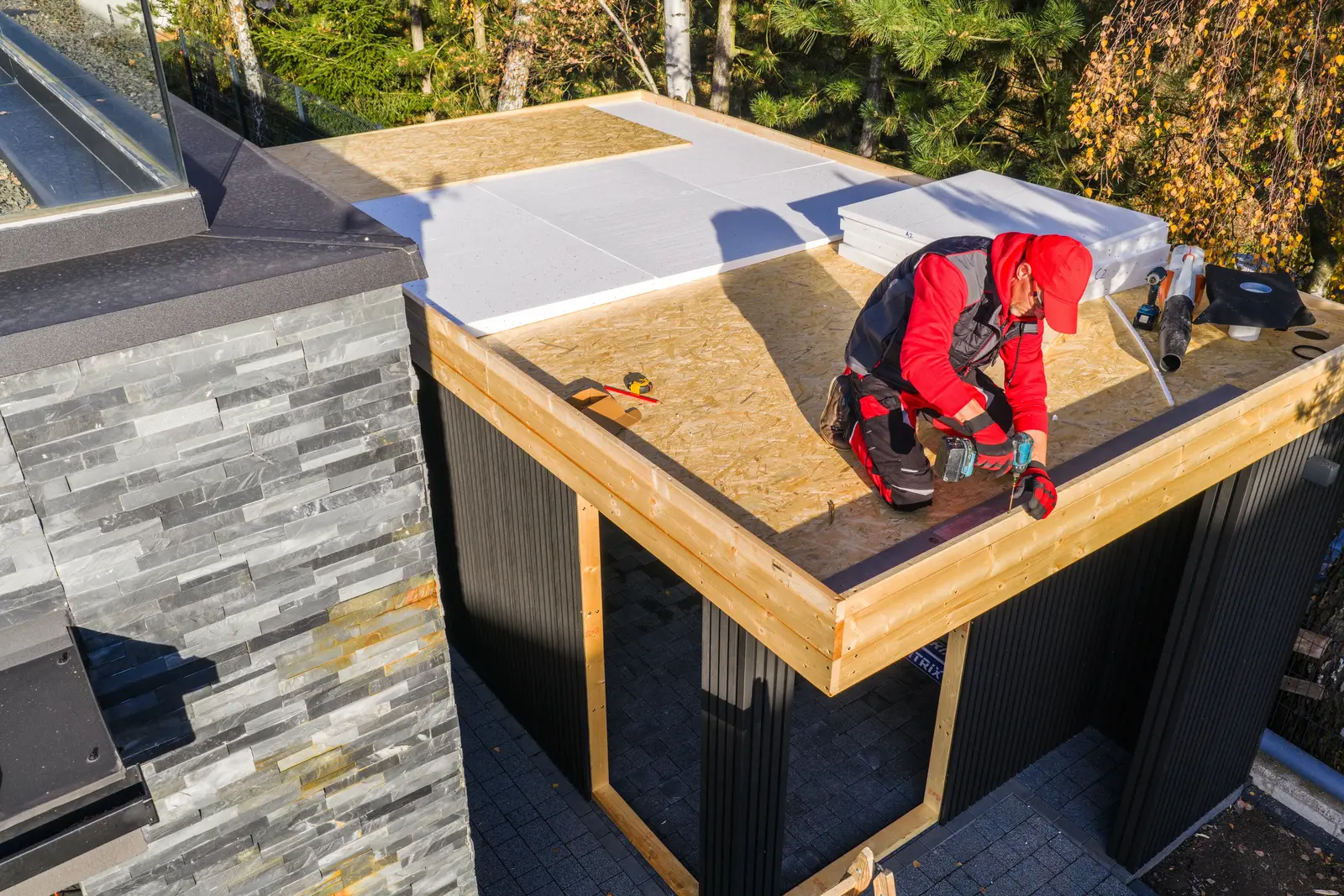 Construction Work on a Flat Roof Structure Near Trees Construction Work on a Flat Roof Structure Near Trees
